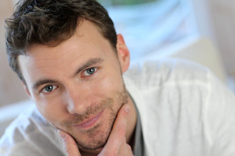 Homem novo de sorriso em casa foto de stock Homem novo de sorriso em casa foto de stock