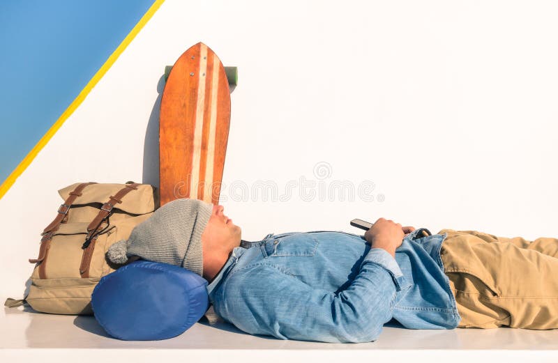 Young hipster man having a rest during a ferry boat passage holding his smartphone - Modern concept of freedom and alternative lifestyle - Cheap travel backpacking around the world. Young hipster man having a rest during a ferry boat passage holding his smartphone - Modern concept of freedom and alternative lifestyle - Cheap travel backpacking around the world