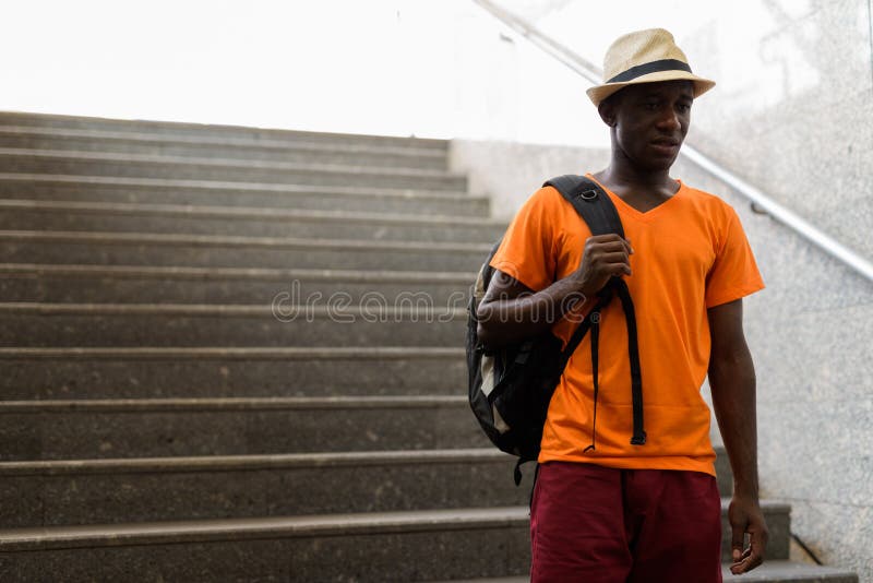 Homem novo do turista do africano negro que anda em escadas fotografia de stock Homem novo do turista do africano negro que anda em escadas fotografia de stock