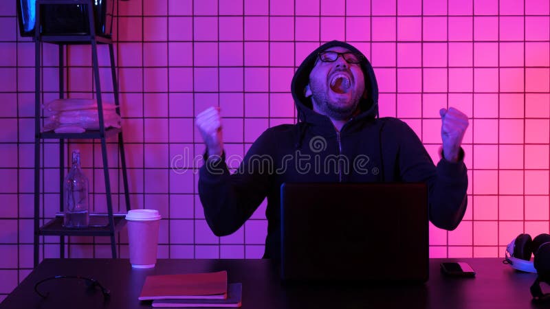 Homem novo feliz nos monóculos que olha o jogo de computador Reação emocional fotos de stock Homem novo feliz nos monóculos que olha o jogo de computador Reação emocional fotos de stock