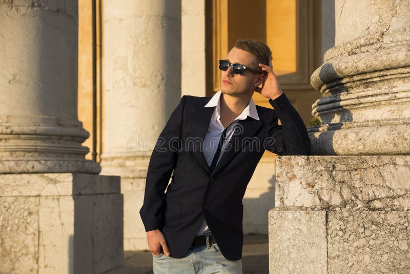 Homem novo louro considerável com as colunas de mármore atrás dele fotos de stock royalty free Homem novo louro considerável com as colunas de mármore atrás dele fotos de stock royalty free