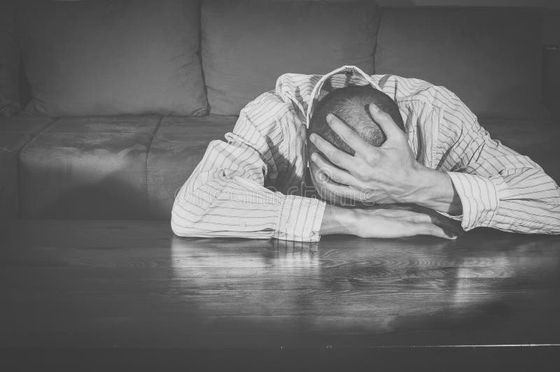 Homem novo miserável que senta-se em sua sala depression Rebecca 36 loneliness sadness confusão Homem ocasional com uma face de g fotos de stock Homem novo miserável que senta-se em sua sala depression Rebecca 36 loneliness sadness confusão Homem ocasional com uma face de g fotos de stock