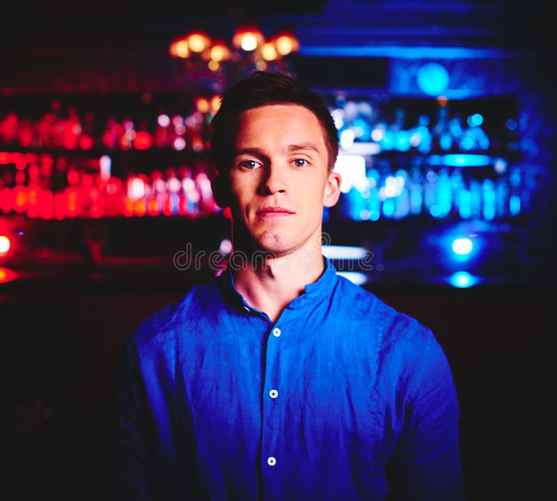 Young man in blue shirt looking at camera in night club. Young man in blue shirt looking at camera in night club