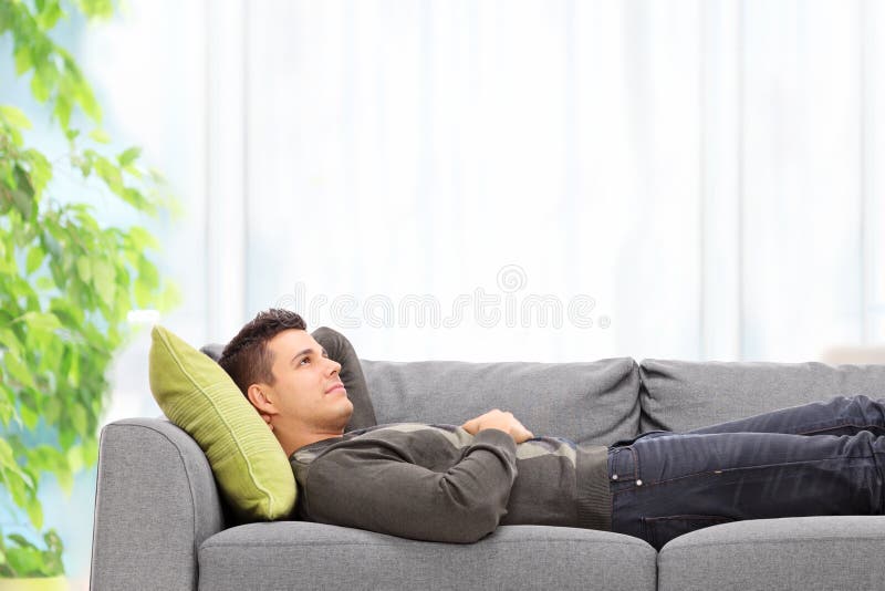 Homem novo que encontra-se em um sofá em casa