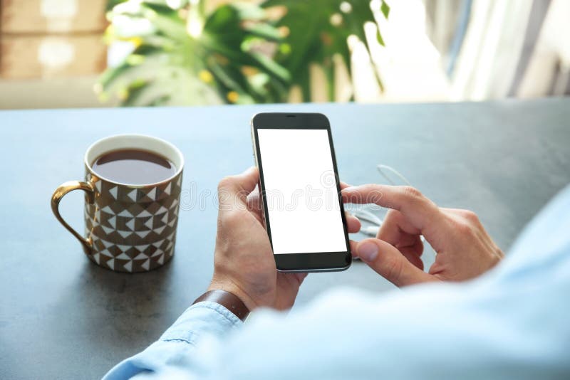 Homem novo que guarda o telefone celular com a tabela excedente disponivel da tela fotos de stock Homem novo que guarda o telefone celular com a tabela excedente disponivel da tela fotos de stock