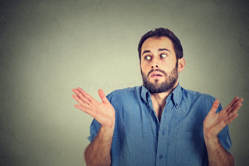 Homem novo que shrugging ombros que se importa assim o que eu não conheço imagens de stock Homem novo que shrugging ombros que se importa assim o que eu não conheço imagens de stock