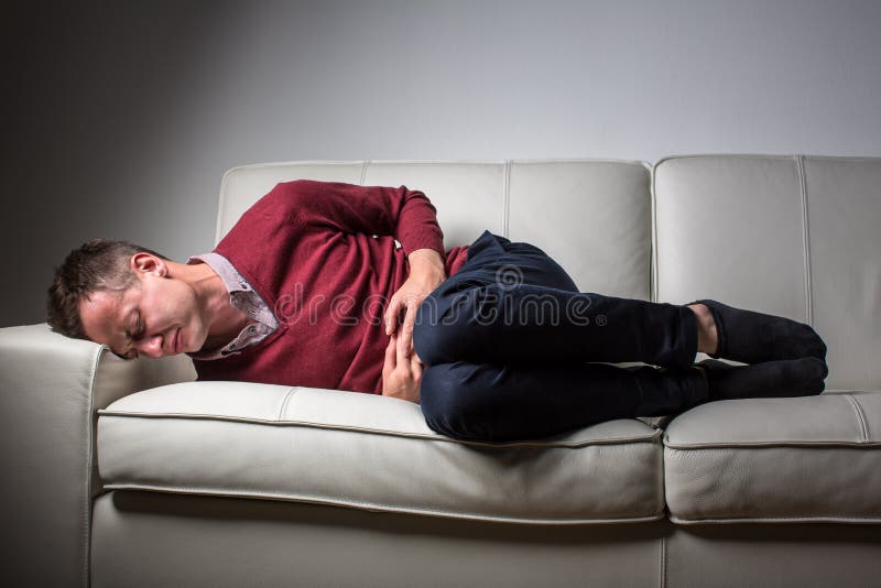 Jovem a sofrer de fortes dores de barriga fotografia de stock