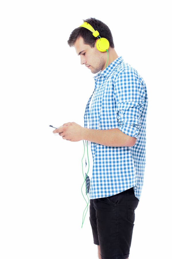 Homem novo que texting em seu telefone e que escuta a música Isolado no fundo branco Copie o espaço Zombaria acima Conversa do es fotos de stock royalty free Homem novo que texting em seu telefone e que escuta a música Isolado no fundo branco Copie o espaço Zombaria acima Conversa do es fotos de stock royalty free