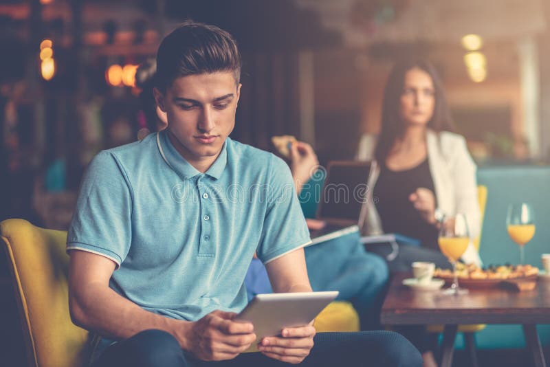 Homem novo que usa a tabuleta digital no escritório startup moderno imagem de stock Homem novo que usa a tabuleta digital no escritório startup moderno imagem de stock