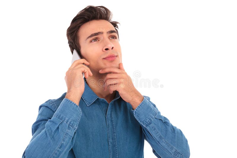 Homem ocasional novo pensativo que fala no telefone imagens de stock royalty free Homem ocasional novo pensativo que fala no telefone imagens de stock royalty free