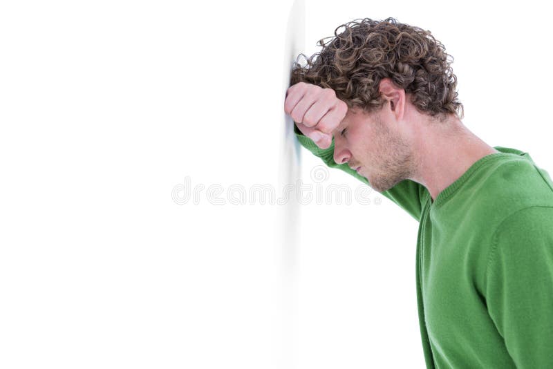 Homem ocasional triste que inclina-se contra a parede imagens de stock royalty free Homem ocasional triste que inclina-se contra a parede imagens de stock royalty free
