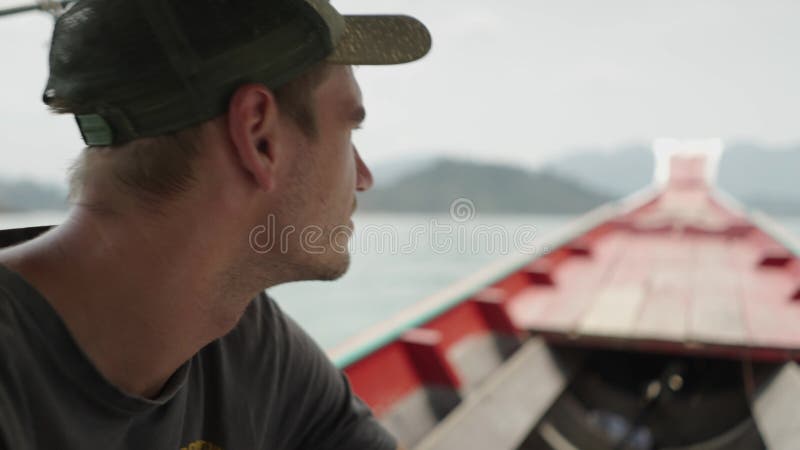 Homem ocidental num chapéu num barco