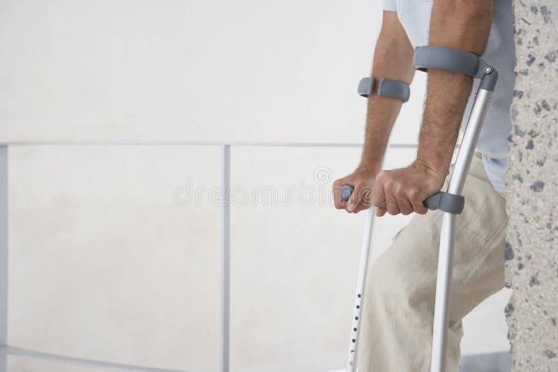 Homem que anda com muletas foto de stock royalty free Homem que anda com muletas foto de stock royalty free