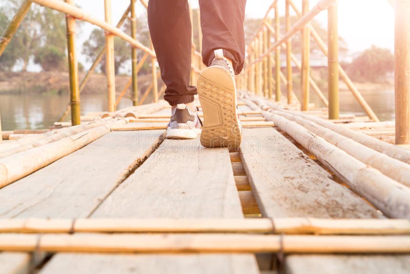 homem que anda, homem do sucesso do viajante que anda ao sucesso na ponte de bambu de madeira longa fotos de stock homem que anda, homem do sucesso do viajante que anda ao sucesso na ponte de bambu de madeira longa fotos de stock