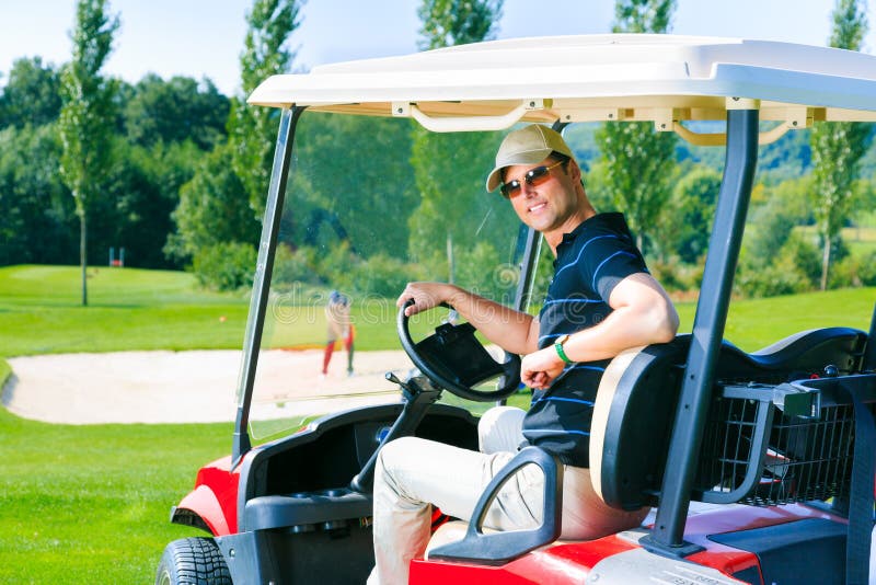Homem que conduz um carrinho de golfe imagem de stock Homem que conduz um carrinho de golfe imagem de stock