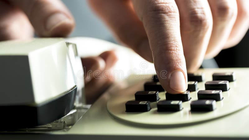 Homem que disca em um telefone da linha terrestre foto de stock royalty free Homem que disca em um telefone da linha terrestre foto de stock royalty free