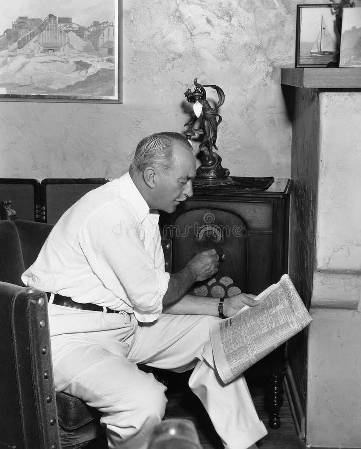Homem que escuta o rádio e que lê o jornal (todas as pessoas descritas não são umas vivas mais longo e nenhuma propriedade existe fotografia de stock royalty free Homem que escuta o rádio e que lê o jornal (todas as pessoas descritas não são umas vivas mais longo e nenhuma propriedade existe fotografia de stock royalty free