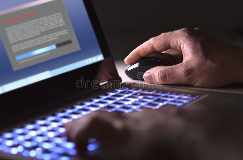 Homem que instala o software no portátil na obscuridade na noite imagens de stock royalty free Homem que instala o software no portátil na obscuridade na noite imagens de stock royalty free