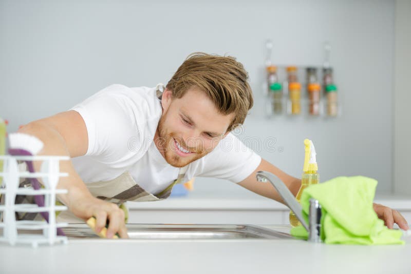 Homem que limpa o dissipador foto de stock Homem que limpa o dissipador foto de stock
