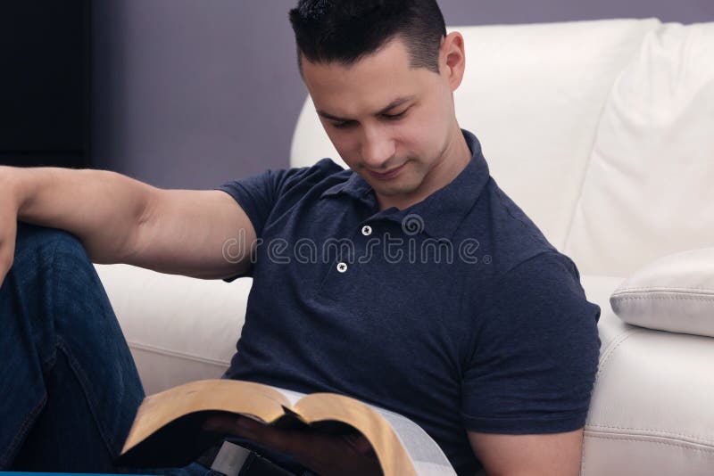 Homem que lê a Bíblia santamente foto de stock Homem que lê a Bíblia santamente foto de stock