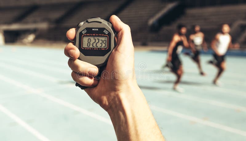 Homem que mantém o tempo em uma raça de corrida usando o cronômetro imagem de stock royalty free Homem que mantém o tempo em uma raça de corrida usando o cronômetro imagem de stock royalty free