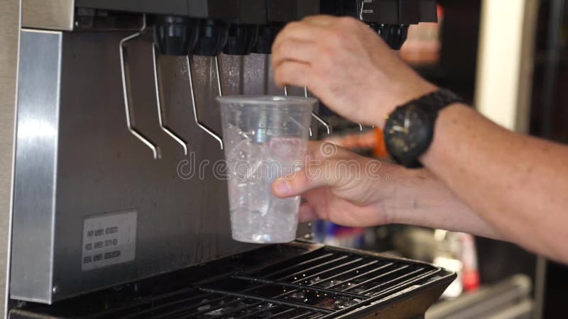 Homem que seleciona a bebida fresca da fonte