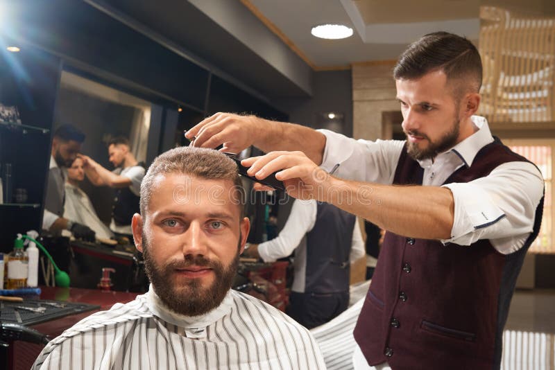 Uma cadeira de barbeiro em uma barbearia com um espelho na parede