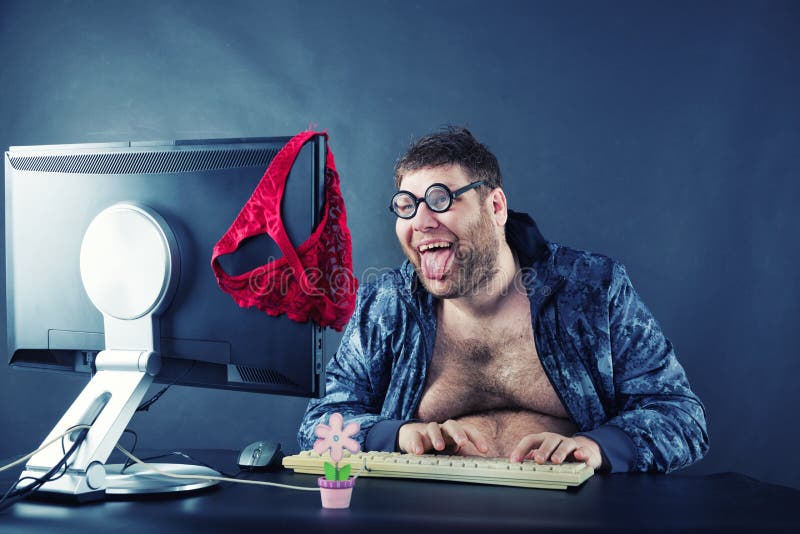 Homem que senta-se na mesa que olha no tela de computador foto de stock royalty free Homem que senta-se na mesa que olha no tela de computador foto de stock royalty free