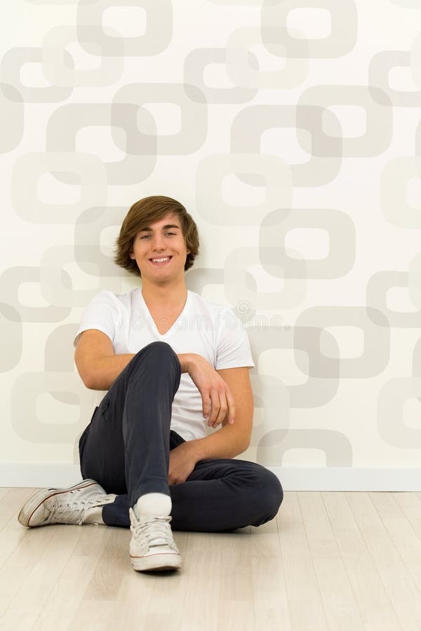 Homem que senta-se no assoalho imagem de stock royalty free Homem que senta-se no assoalho imagem de stock royalty free