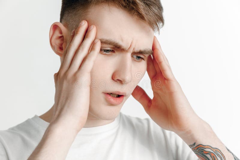Homem que tem a dor de cabeça Isolado sobre o fundo cinzento imagens de stock Homem que tem a dor de cabeça Isolado sobre o fundo cinzento imagens de stock
