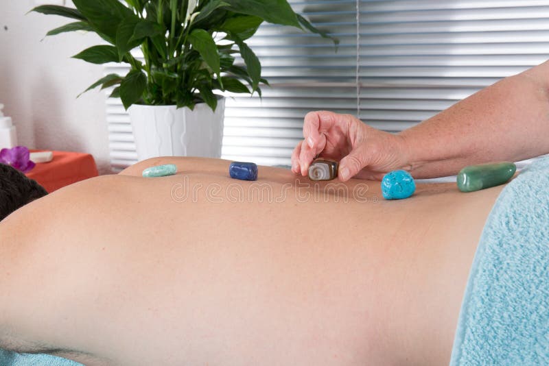 Homem a receber massagem com pedras quentes imagens de stock royalty free