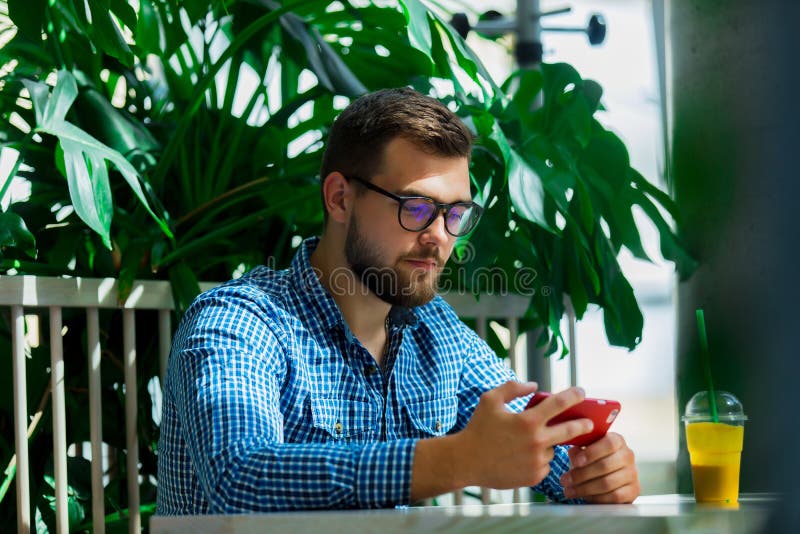 Homem que usa o telefone celular em um caf? fotos de stock Homem que usa o telefone celular em um caf? fotos de stock