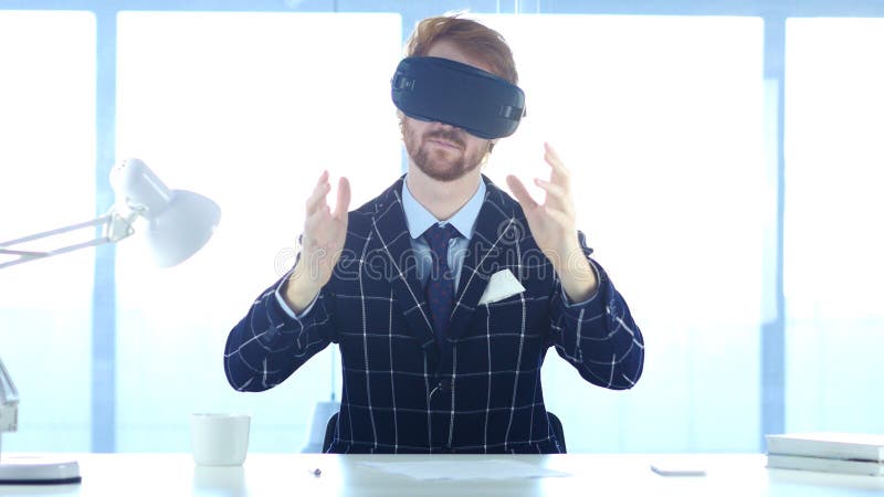 Homem que veste vidros da realidade virtual no escritório utilização com os auriculares dos óculos de proteção de Smartphone VR ? fotografia de stock royalty free Homem que veste vidros da realidade virtual no escritório utilização com os auriculares dos óculos de proteção de Smartphone VR ? fotografia de stock royalty free