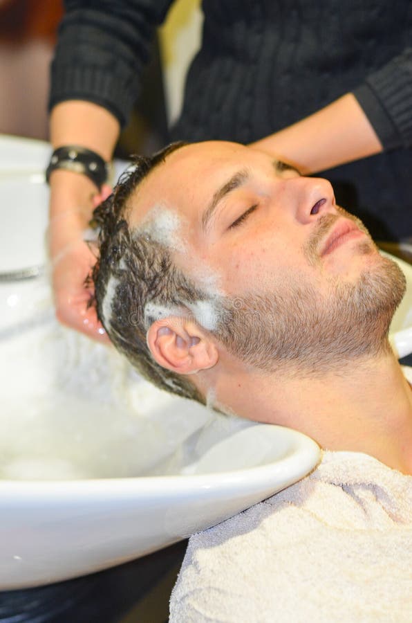 Homem relaxado shampooed por seu cabeleireiro fotos de stock royalty free Homem relaxado shampooed por seu cabeleireiro fotos de stock royalty free