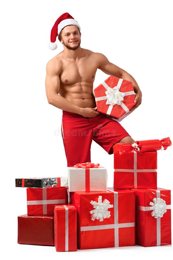 Homem 'sexy' de Santa Claus com uma pilha dos presentes fotografia de stock Homem 'sexy' de Santa Claus com uma pilha dos presentes fotografia de stock