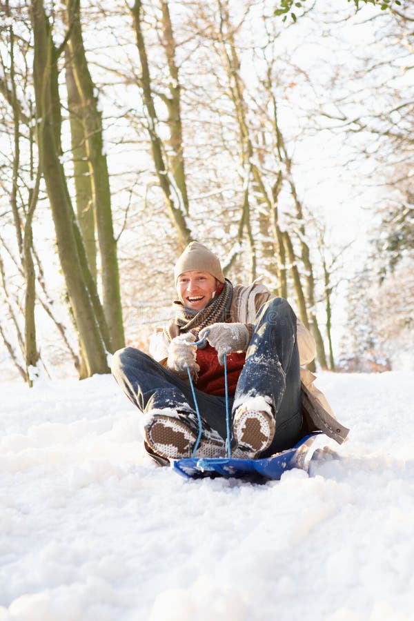 Homem Sledging através da floresta nevado fotografia de stock royalty free Homem Sledging através da floresta nevado fotografia de stock royalty free