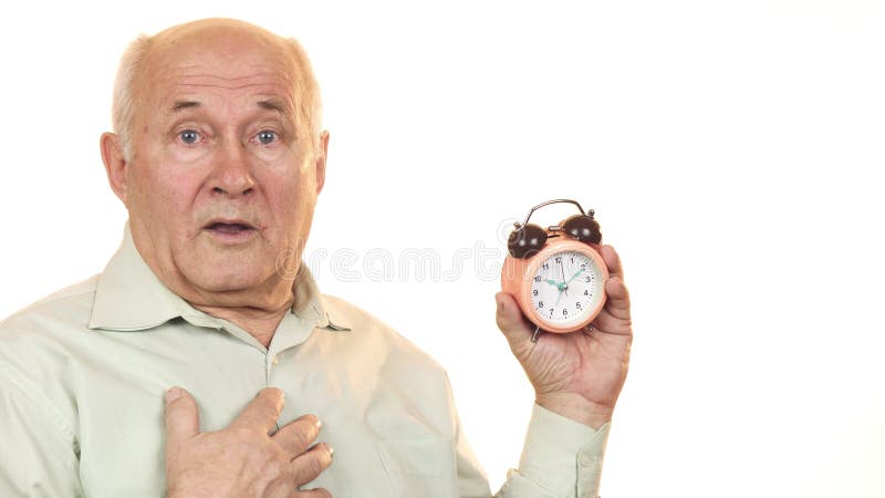 Homem superior que olha chocado verificando o tempo no despertador imagens de stock royalty free Homem superior que olha chocado verificando o tempo no despertador imagens de stock royalty free