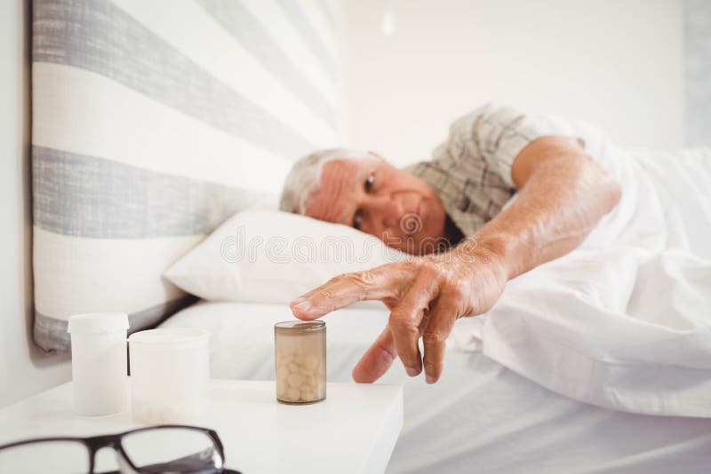 Homem superior que pegara a garrafa de comprimido imagens de stock Homem superior que pegara a garrafa de comprimido imagens de stock