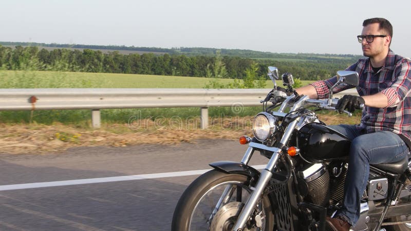 Homem sério com vidros em uma motocicleta Tiro aéreo