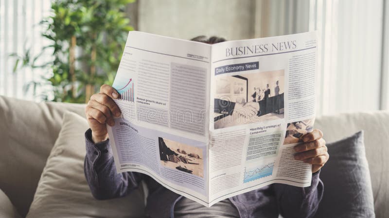 Homem sênior lendo jornal em casa foto de stock Homem sênior lendo jornal em casa foto de stock