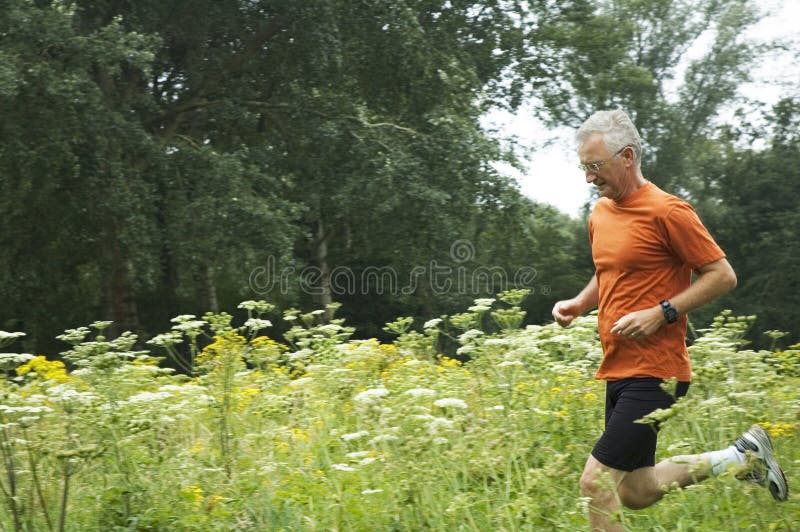 Senior man is running through a field of flowers. Senior man is running through a field of flowers.