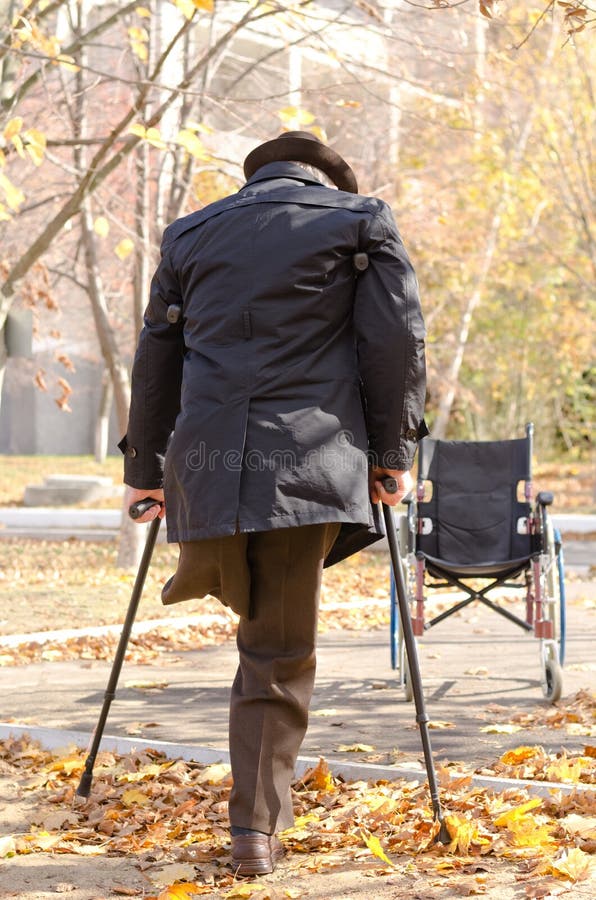 Homem um-equipado com pernas deficiente que anda em muletas imagem de stock royalty free Homem um-equipado com pernas deficiente que anda em muletas imagem de stock royalty free