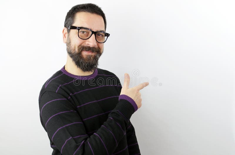 Bearded man wearing casual clothes and glasses with a smile of face pointing with hand and finger up to the side. Bearded man wearing casual clothes and glasses with a smile of face pointing with hand and finger up to the side