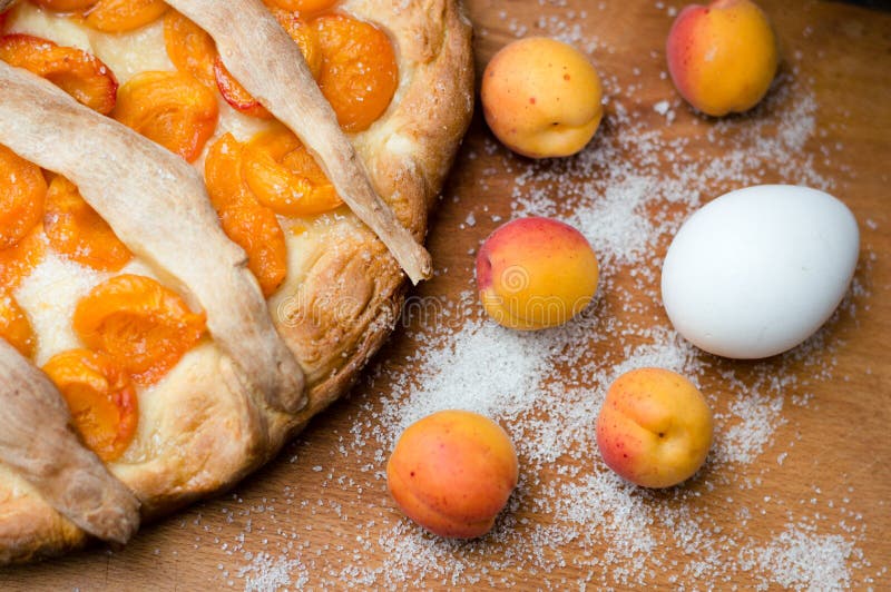 Homemade apricot pie closeup with fresh fruit and egg