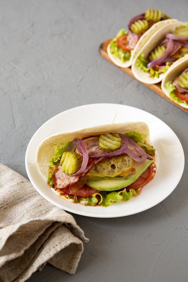 Homemade Bacon Cheeseburger Tacos on a Gray Surface, Side View Stock