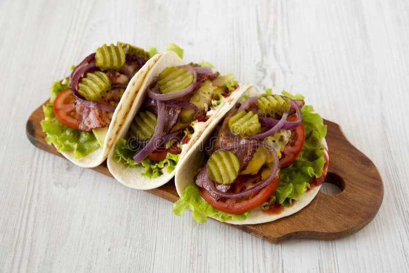 Homemade Bacon Cheeseburger Tacos on a Rustic Wooden Board on a White