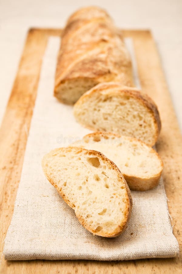 Homemade baguette, a French crusty long bread, with slices apart.