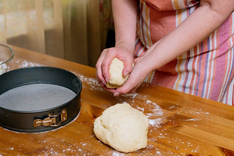 Homemade baking process with pastry dough and hands shaping pie crust on kitchen table royalty free stock photo