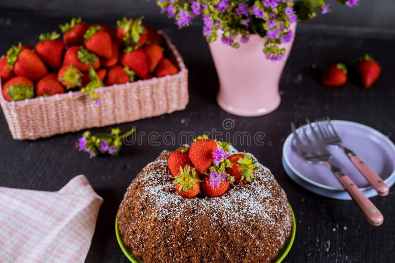 Homemade bundt cake with fresh strawberries ,plate ,vase with flowers stock photography Homemade bundt cake with fresh strawberries ,plate ,vase with flowers stock photography