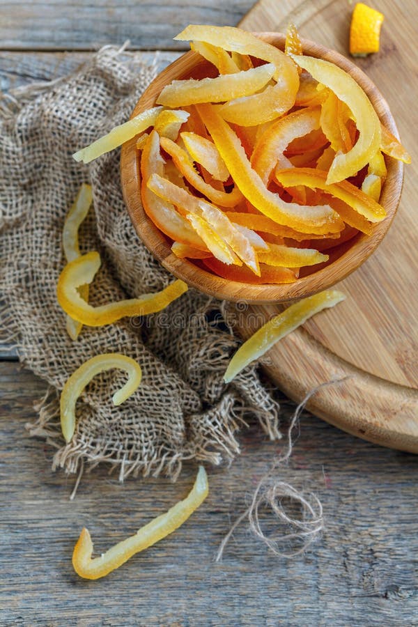 Homemade candied citrus fruit in a wooden bowl on the old sacking. Homemade candied citrus fruit in a wooden bowl on the old sacking.